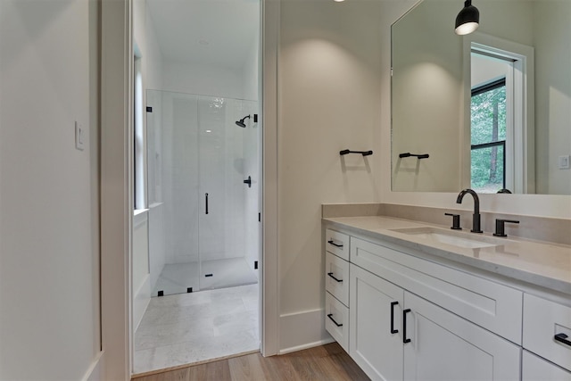 bathroom with vanity, hardwood / wood-style flooring, and a shower with door