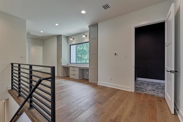 empty room featuring light hardwood / wood-style floors and built in desk