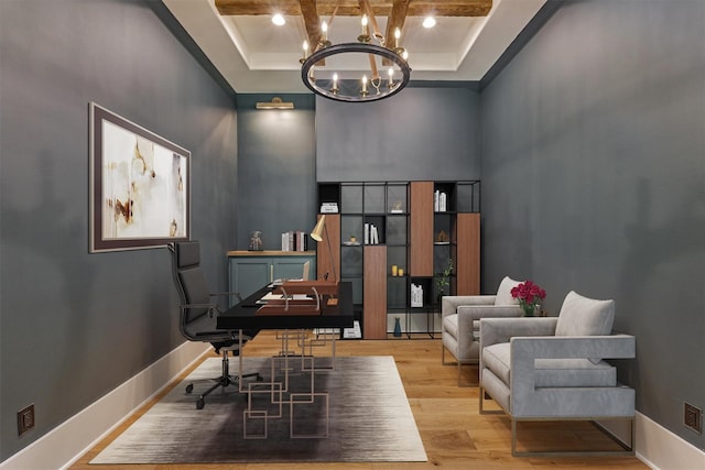 office space with beam ceiling, light hardwood / wood-style flooring, a tray ceiling, and coffered ceiling