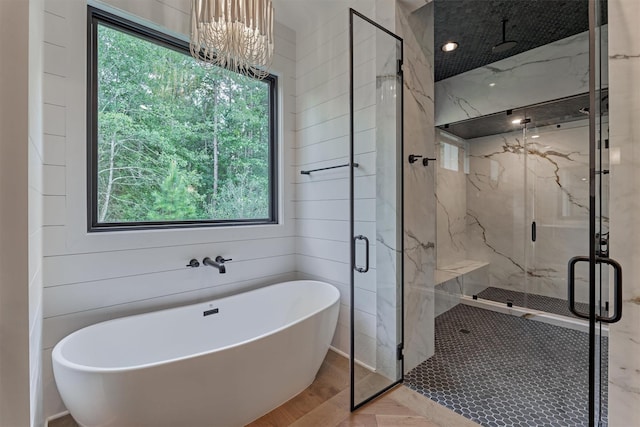 bathroom with wood walls, plus walk in shower, a wealth of natural light, and an inviting chandelier