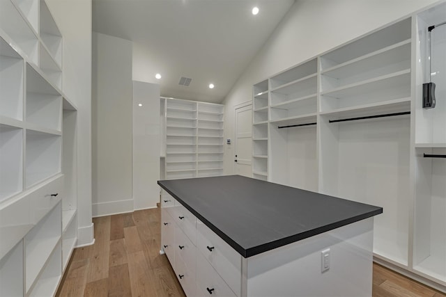 walk in closet with lofted ceiling and light wood-type flooring