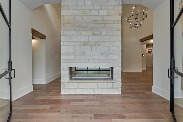 living room with a fireplace, wood-type flooring, and a notable chandelier