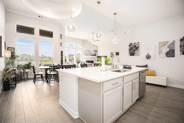 kitchen featuring a center island with sink, decorative light fixtures, dark hardwood / wood-style flooring, and sink