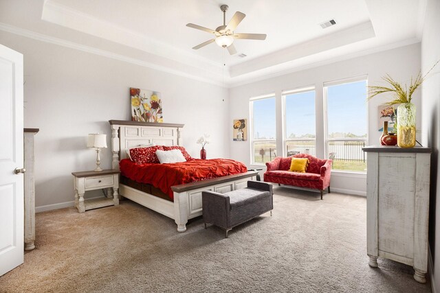 bedroom featuring carpet flooring, ceiling fan, crown molding, and a tray ceiling