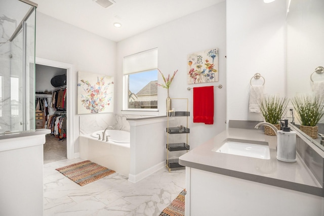 bathroom with vanity and shower with separate bathtub