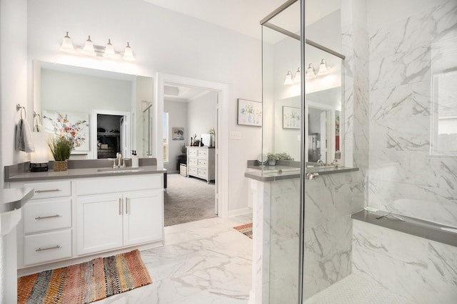 bathroom with tiled shower and vanity