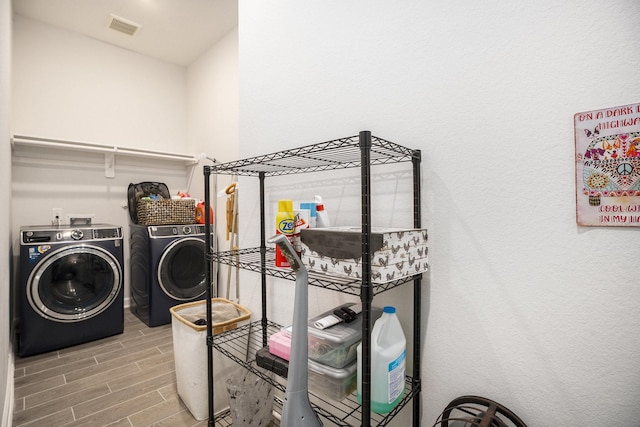 clothes washing area with washer and clothes dryer and hardwood / wood-style floors