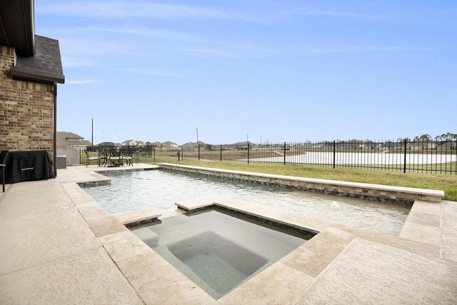 view of swimming pool with pool water feature and a hot tub