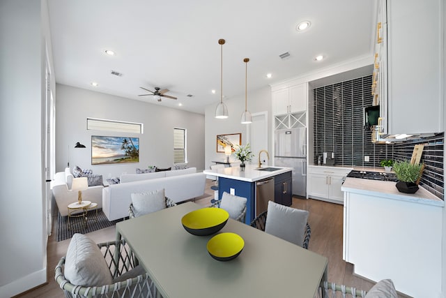 dining area featuring dark wood-type flooring, ceiling fan, and sink