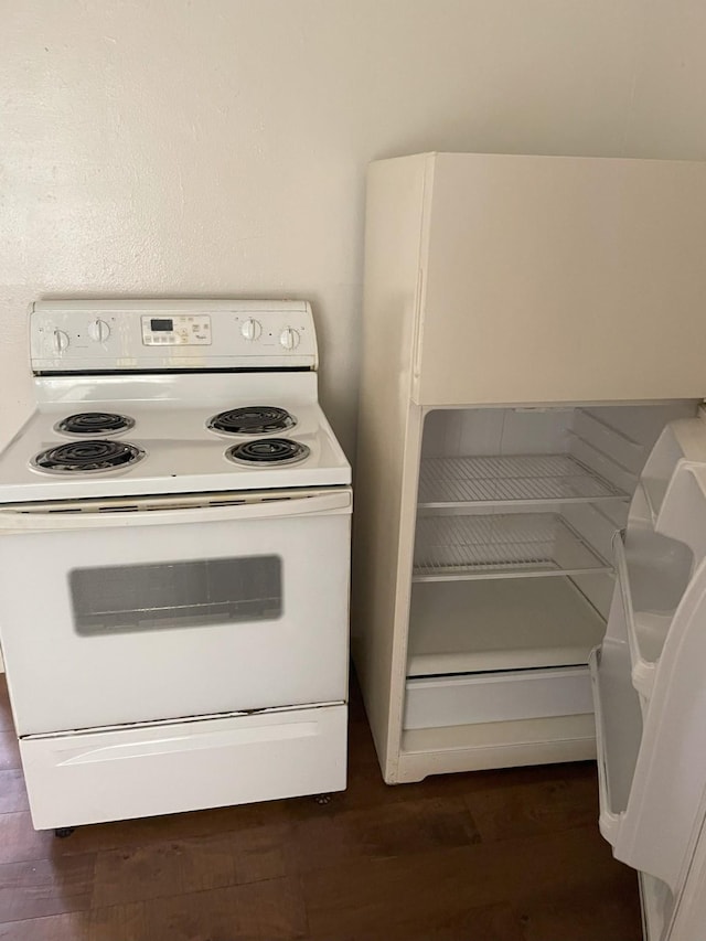 kitchen with electric range, dark wood-type flooring, and fridge