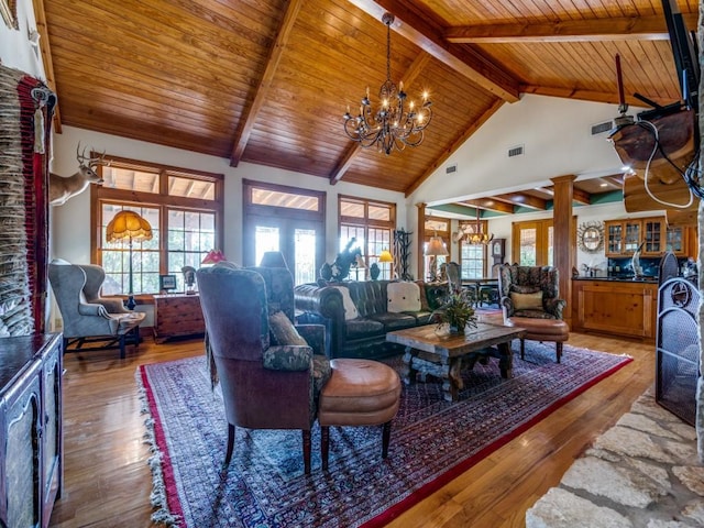 living room with ornate columns, wooden ceiling, an inviting chandelier, high vaulted ceiling, and hardwood / wood-style floors