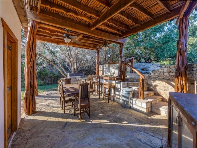 view of patio with area for grilling, ceiling fan, and exterior kitchen