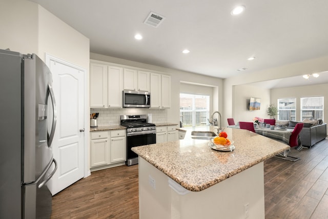 kitchen featuring a center island with sink, white cabinets, sink, dark hardwood / wood-style flooring, and stainless steel appliances