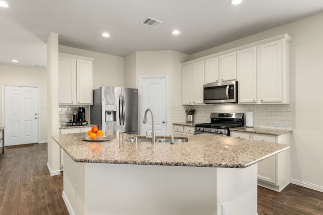 kitchen with white cabinets, appliances with stainless steel finishes, a kitchen island with sink, and sink