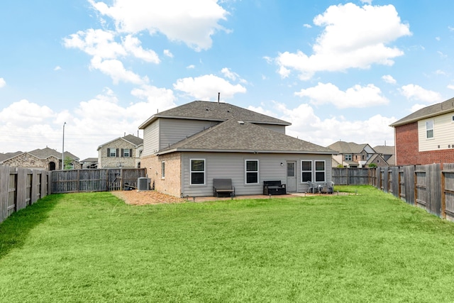 rear view of property with a yard and central AC