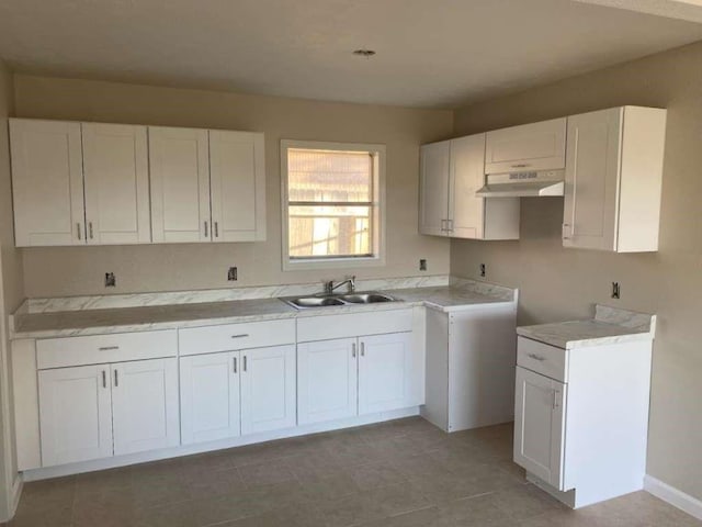 kitchen with white cabinetry, sink, and light tile patterned flooring