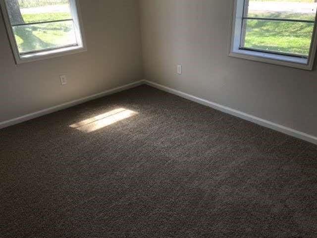 empty room featuring dark carpet