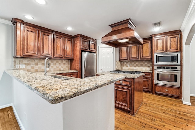 kitchen featuring appliances with stainless steel finishes, light wood-type flooring, crown molding, and sink