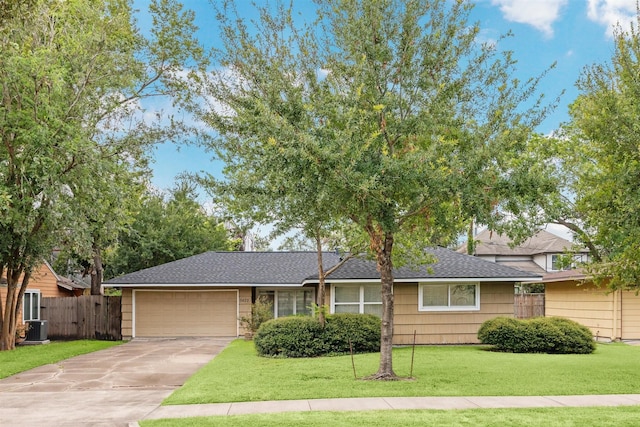 view of front of house featuring a front lawn, a garage, and cooling unit