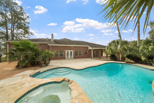 view of pool featuring a patio area, an in ground hot tub, and french doors