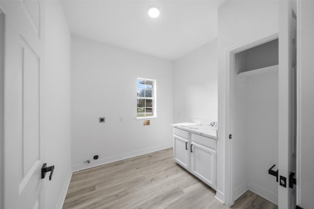 washroom with hookup for an electric dryer and light hardwood / wood-style floors