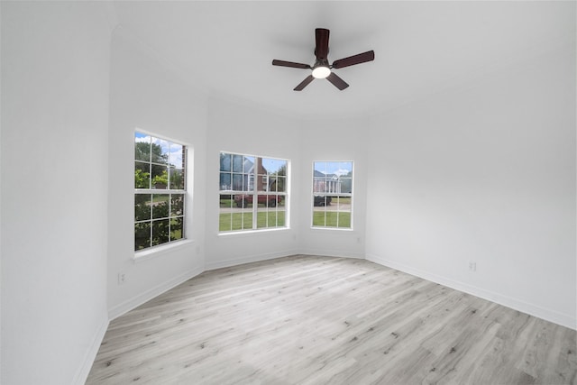 spare room featuring ceiling fan, light hardwood / wood-style floors, ornamental molding, and a wealth of natural light