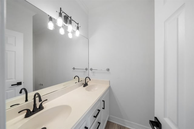 bathroom featuring wood-type flooring, vanity, and ornamental molding