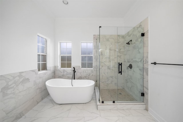 bathroom with crown molding, plus walk in shower, and tile walls