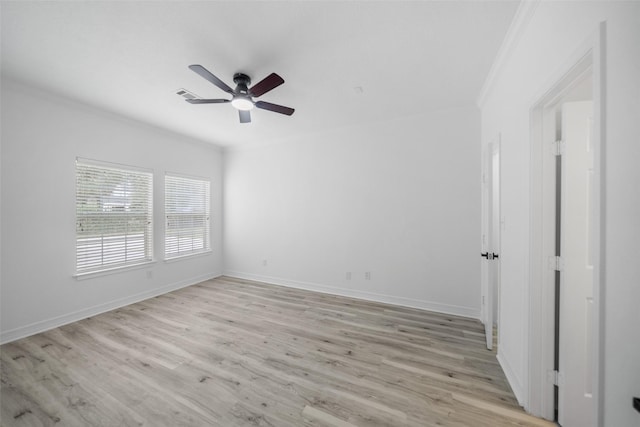 spare room featuring light wood-type flooring, ceiling fan, and ornamental molding