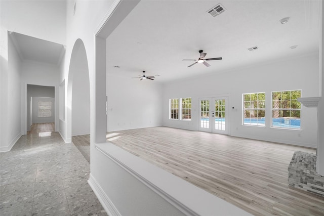 spare room featuring french doors, light wood-type flooring, plenty of natural light, and ceiling fan