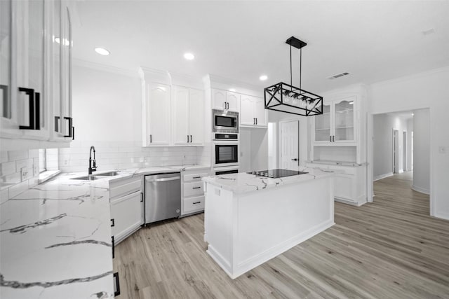 kitchen with white cabinetry, sink, a kitchen island, and appliances with stainless steel finishes