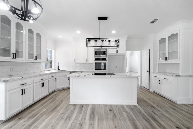 kitchen with a center island, stainless steel appliances, white cabinetry, and sink