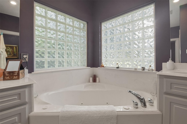 bathroom with a washtub, vanity, and a wealth of natural light