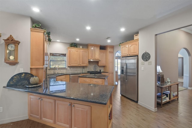 kitchen featuring kitchen peninsula, light brown cabinets, stainless steel appliances, and light hardwood / wood-style floors