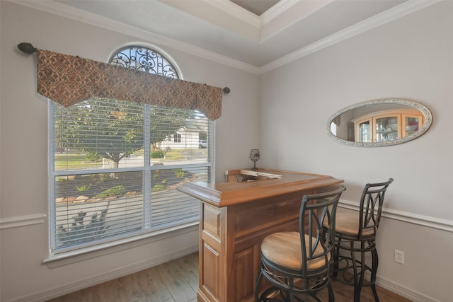 office area featuring bar, crown molding, and light hardwood / wood-style floors