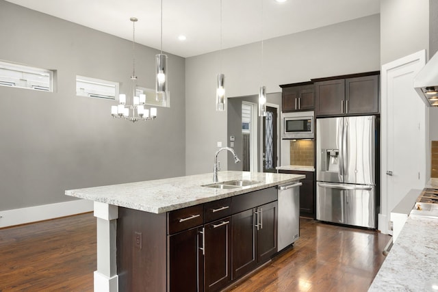 kitchen featuring appliances with stainless steel finishes, backsplash, dark brown cabinets, sink, and pendant lighting