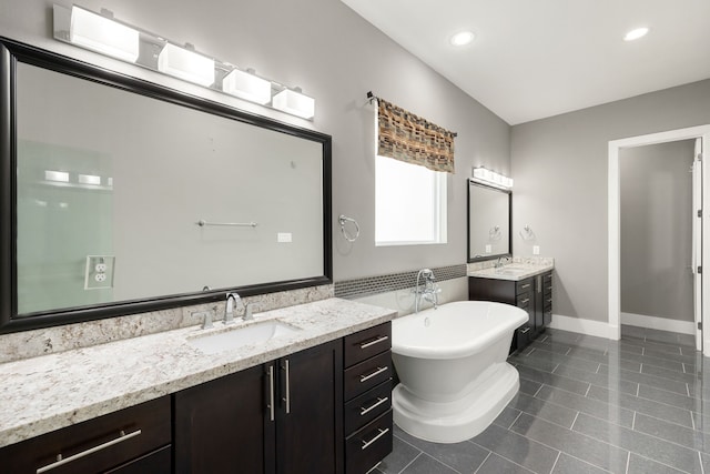 bathroom with tile patterned floors, a bathing tub, and vanity