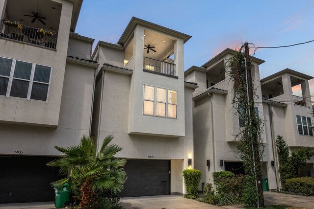 view of front of property with ceiling fan, a garage, and a balcony