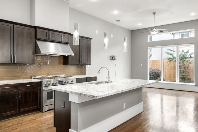 kitchen featuring ceiling fan, a kitchen island with sink, high end stainless steel range, and sink