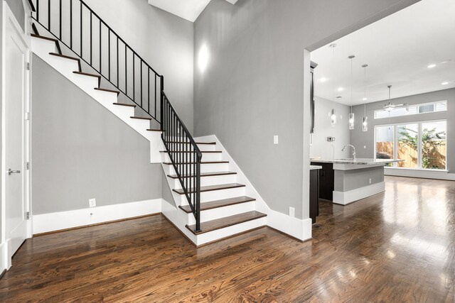 stairway featuring hardwood / wood-style flooring, ceiling fan, and sink