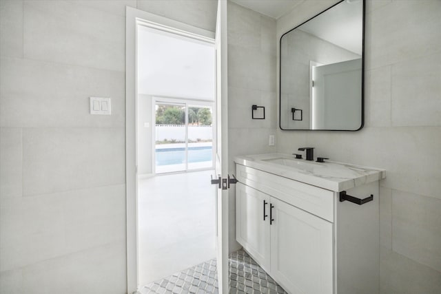 bathroom with vanity and tile walls