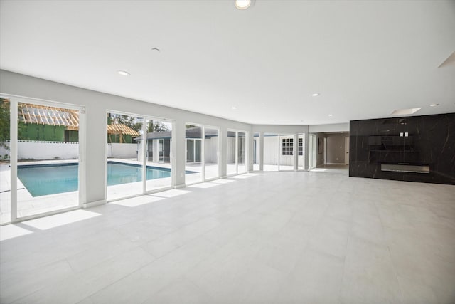 unfurnished living room featuring light tile patterned floors and a healthy amount of sunlight