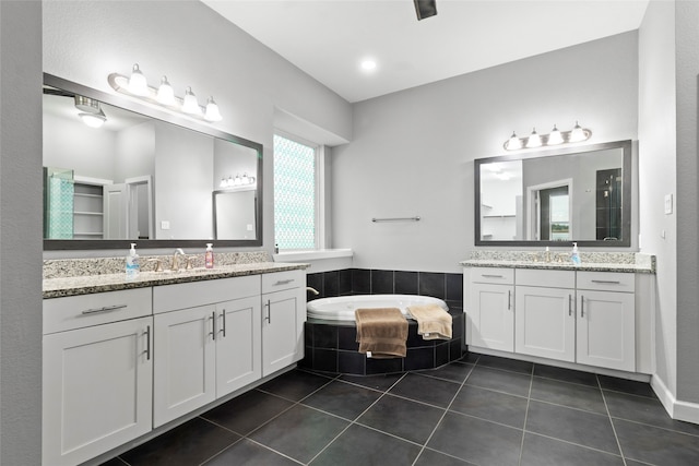 bathroom with vanity, a relaxing tiled tub, and tile patterned floors