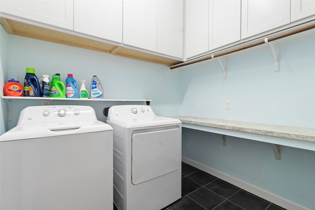 laundry room with cabinets, washing machine and dryer, and dark tile patterned floors