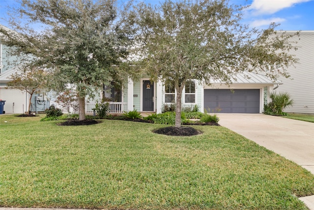 view of front of home featuring covered porch, a garage, and a front yard