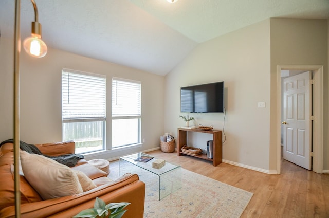 living room featuring light hardwood / wood-style floors and vaulted ceiling