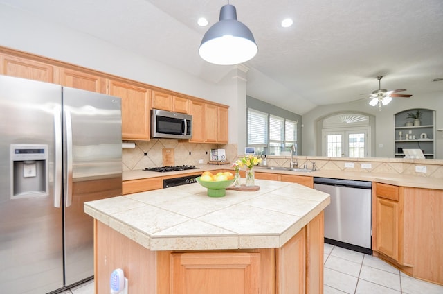 kitchen with ceiling fan, sink, a center island, hanging light fixtures, and appliances with stainless steel finishes