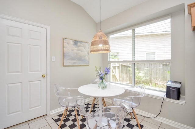 tiled dining area featuring lofted ceiling