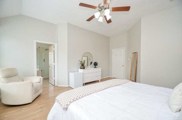 bedroom featuring light wood-type flooring, ensuite bath, vaulted ceiling, and ceiling fan