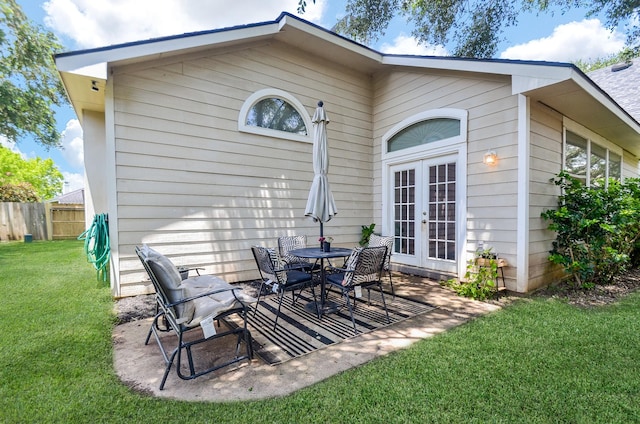 rear view of house featuring a lawn, a patio, and french doors